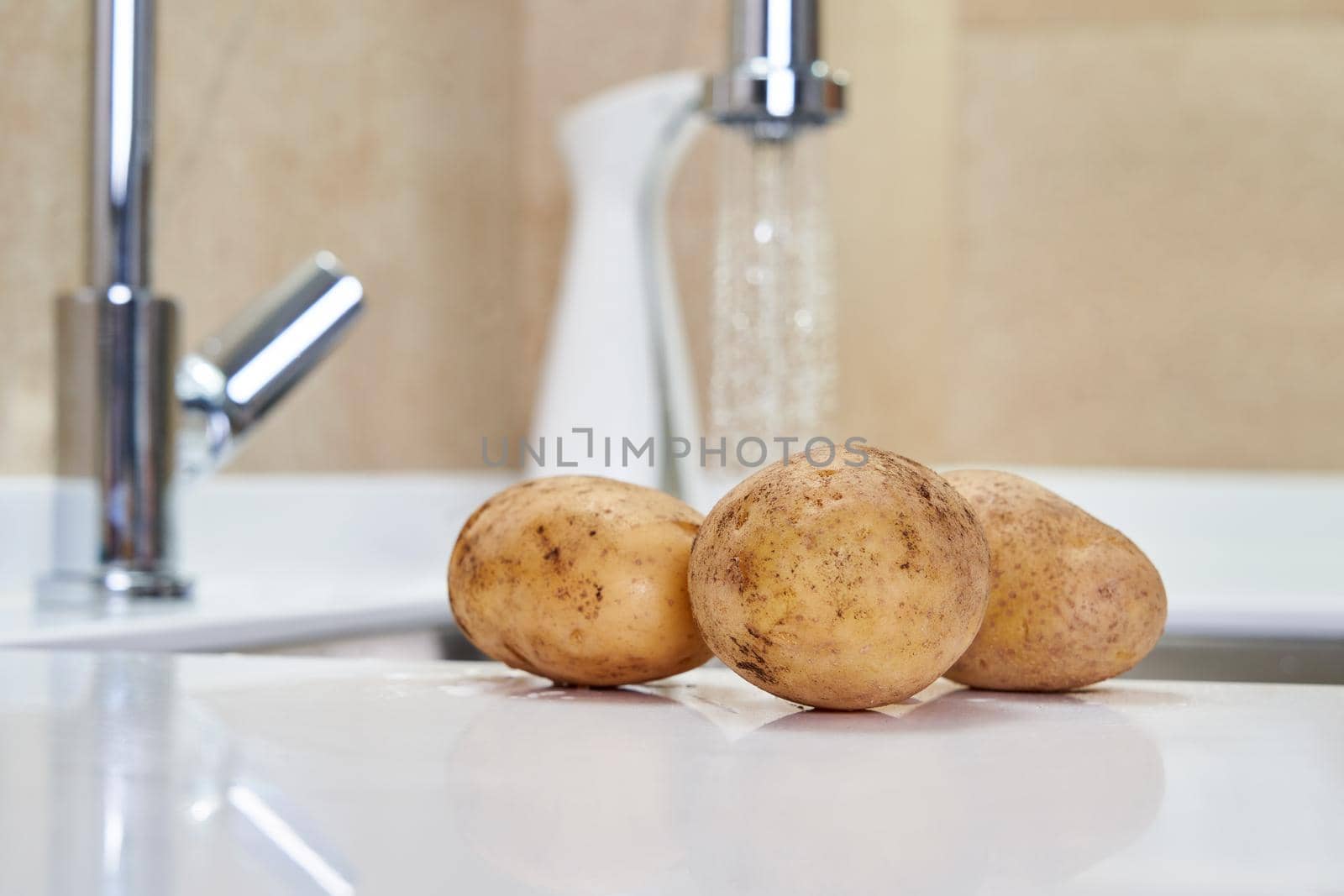 Potato laying near sink ready to be cooked