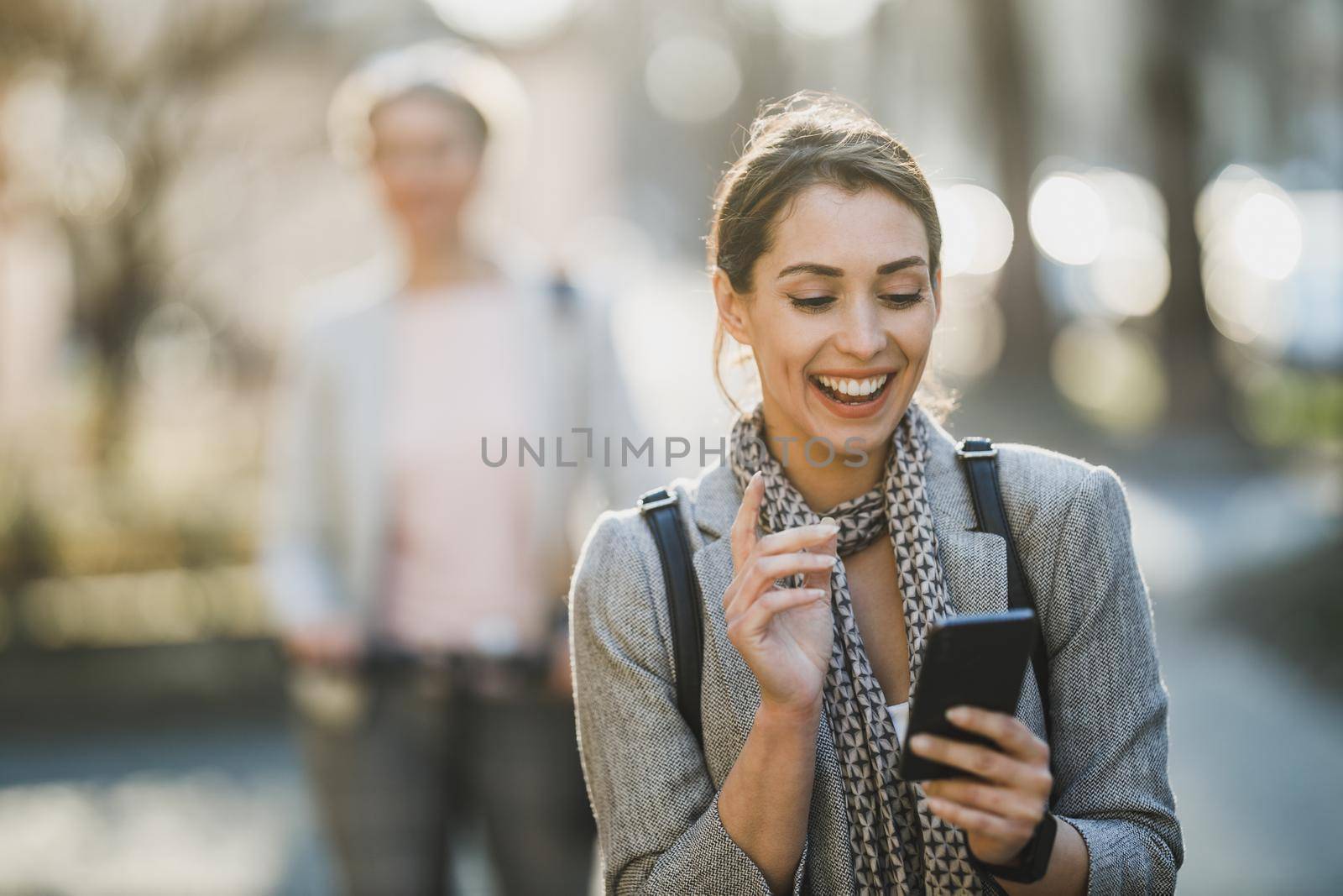 A young businesswoman using smartphone while going to work.