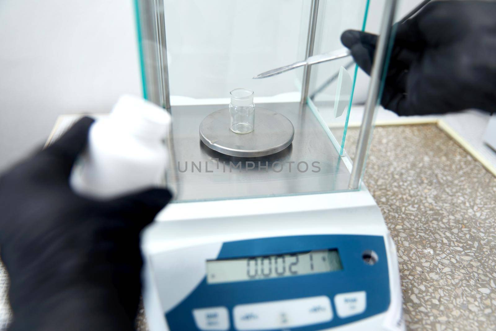 Scientist weighing chemicals by digital scales in grams in the chemical laboratory