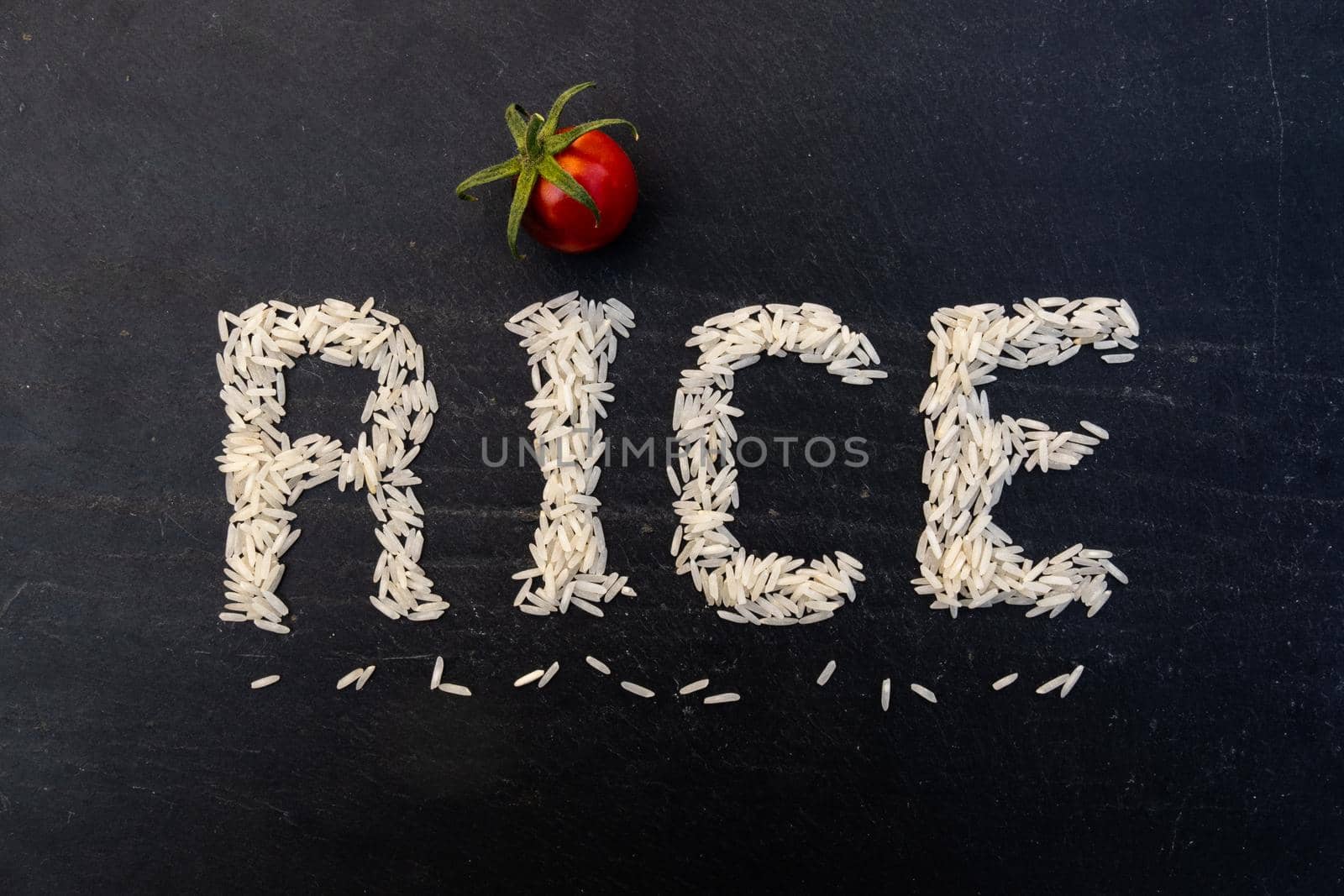 Word rice written with white grains on black slate board