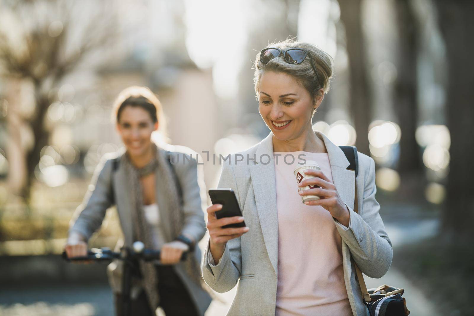 A mature business woman surfing on a smartphone while going to work.