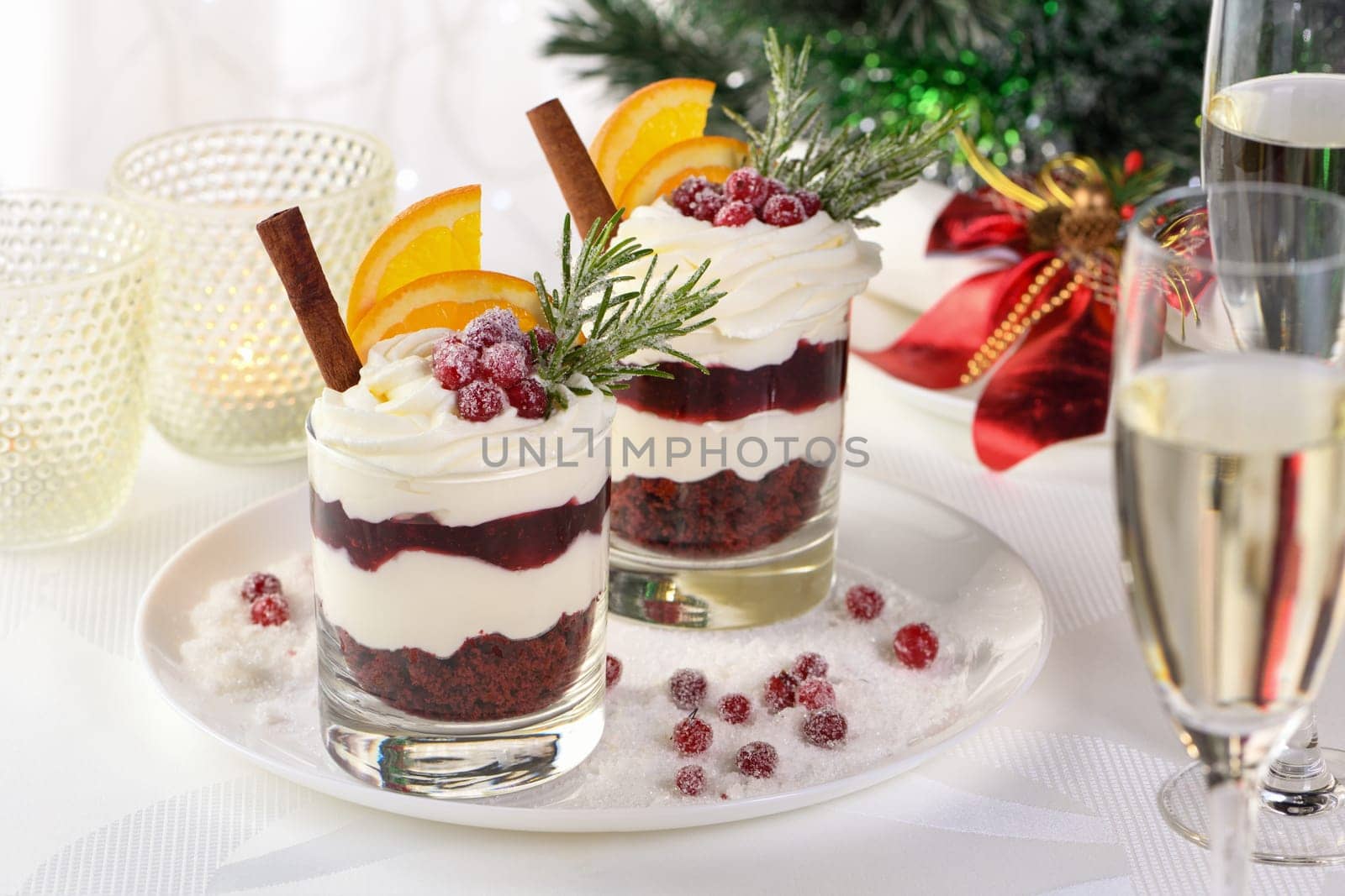 Christmas cranberry dessert tiramisu with mascarpone and whipped cream, chocolate biscuit crumble and cranberry jam, garnished with orange slices, candied cranberries and rosemary.