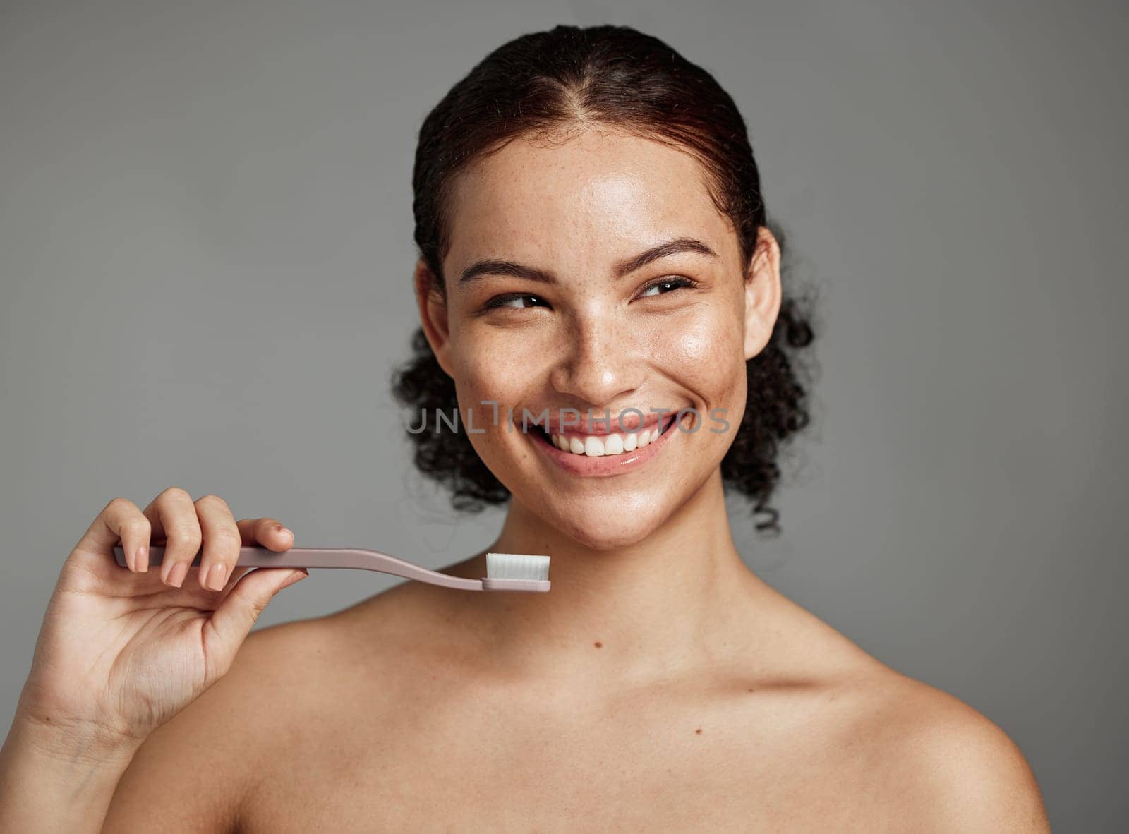 Dental smile, toothbrush and woman brushing teeth for hygiene, cleaning and teeth whitening in studio. Happy female face on grey background for oral health, healthy mouth and self care for wellness.