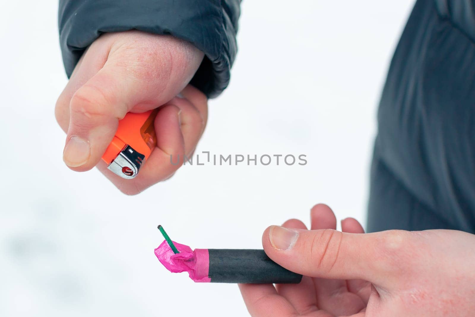 Guy Sets Fire to the Flash Noise Firecracker Outdoors in Winter at Daytime. Loud and Dangerous New Year's Entertainment. Hooliganism with Pyrotechnics. Noise of Petards in Public Places