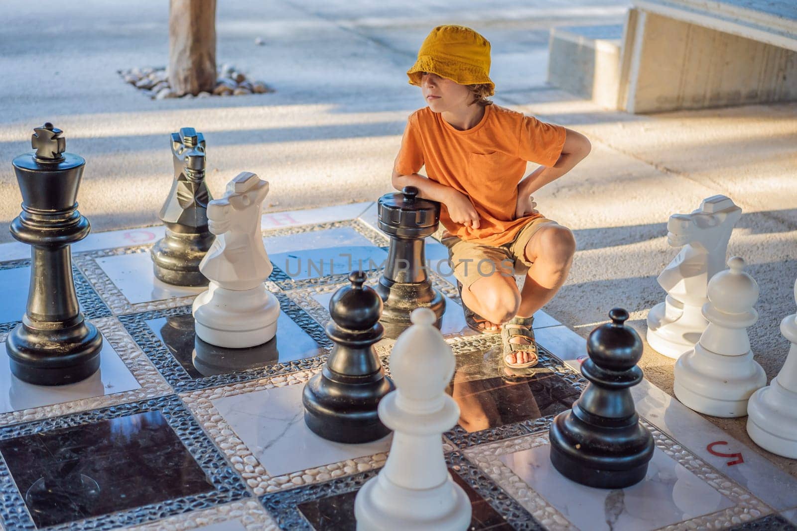 Father and son playing chess spending time together outdoor. Kid play chess.