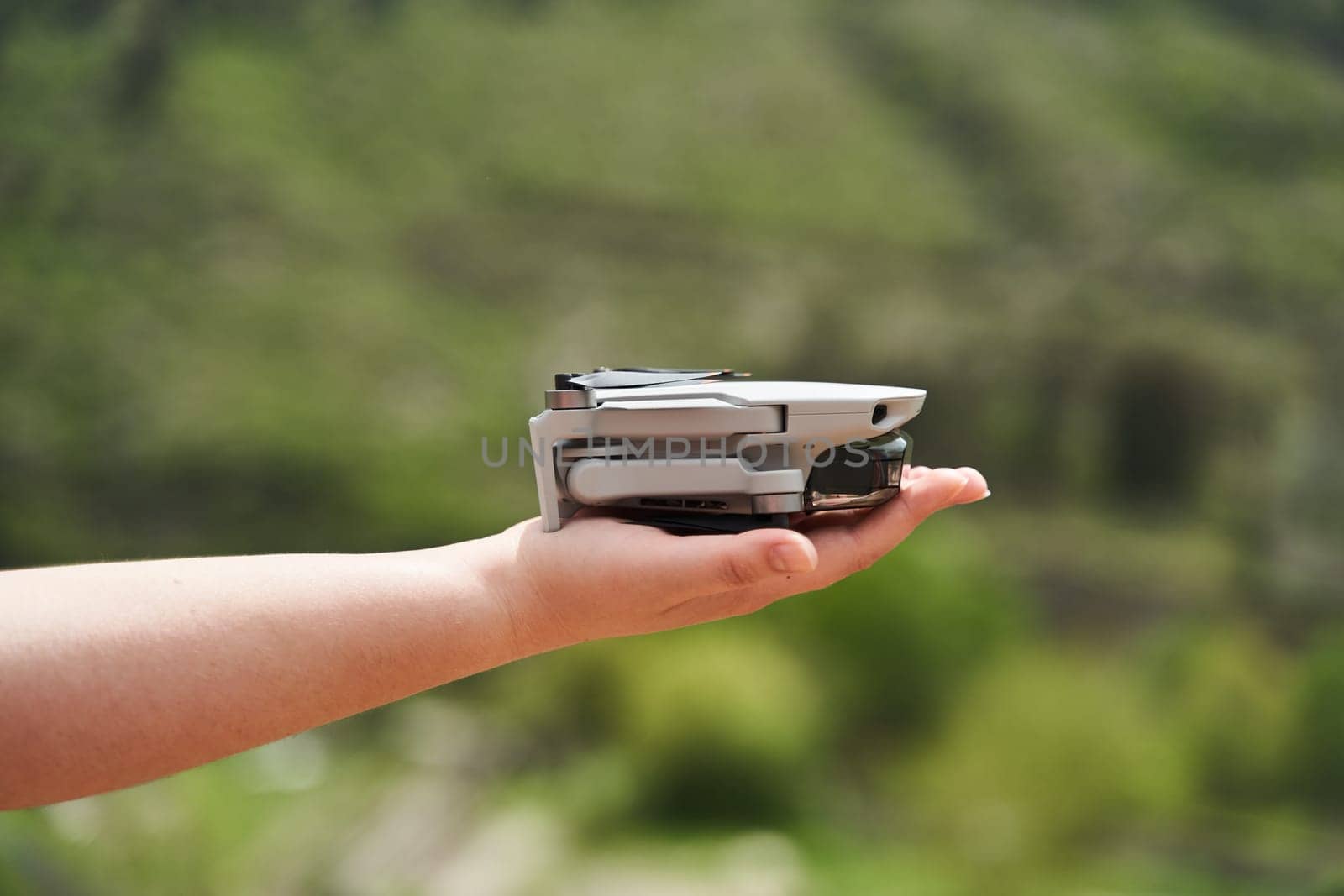 Modern small compact quadcopter in a girl's hand. Launching a drone from your hand. High quality photo