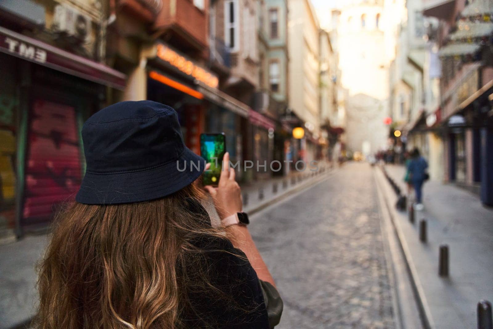 ISTANBUL, TURKEY - 08.05.2021: Young woman photographs the sights of Istanbul on her phone by driver-s