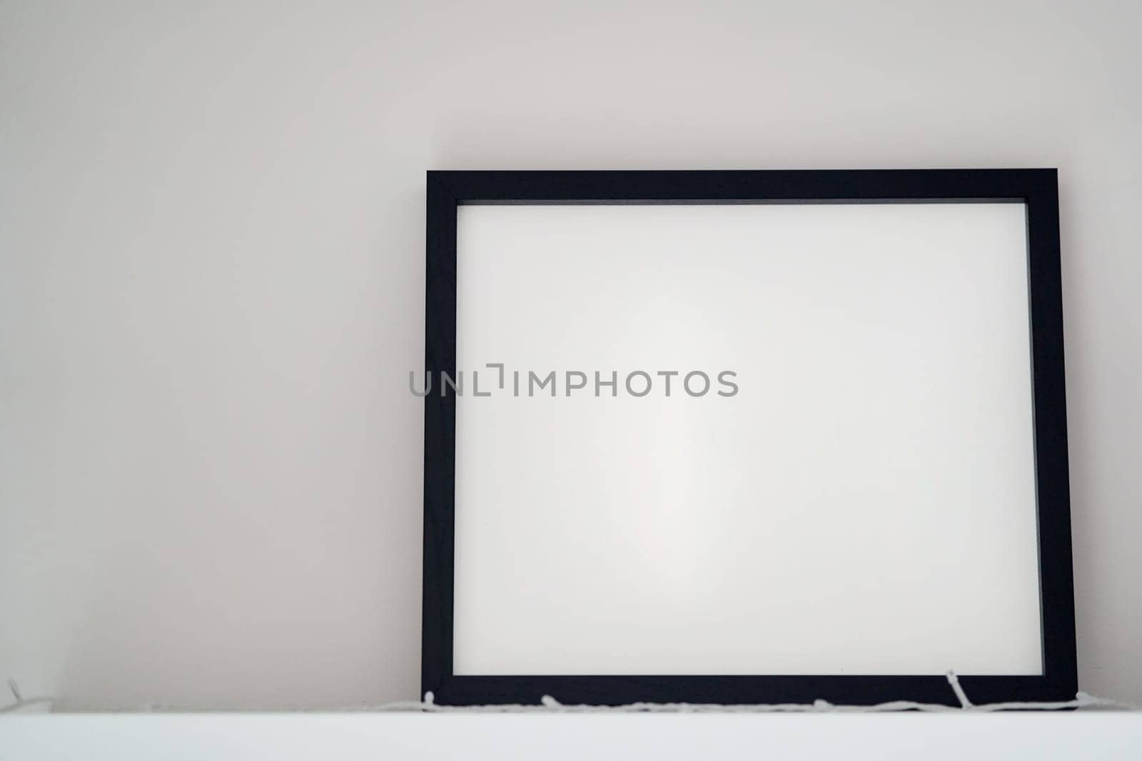 Blank wooden photo frame stands in the interior on a white background. Mockup poster frame close up in home interior. High quality photo