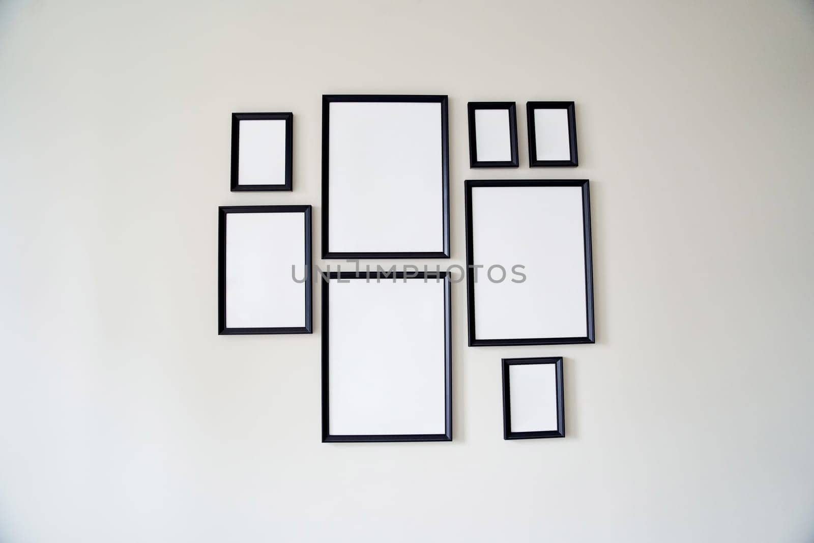 Different size framed photos hanging on the gray wall. Mockup. by driver-s
