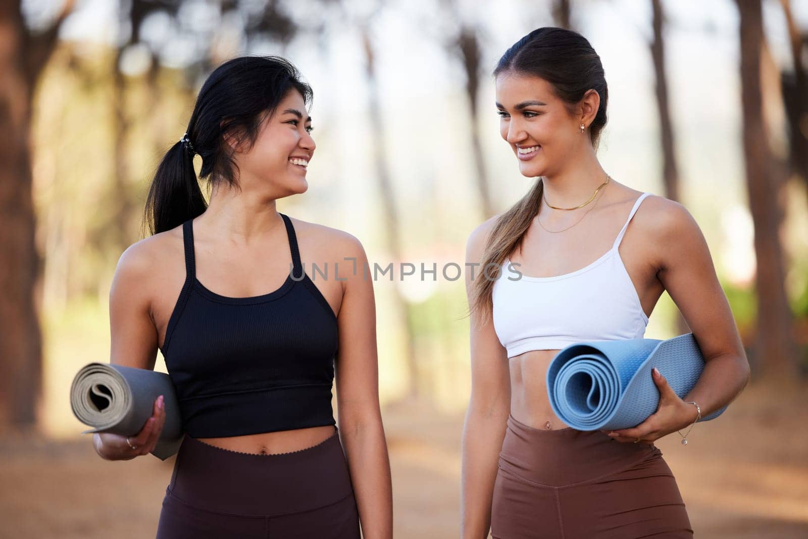 Yoga women, outdoor and exercise in nature in nature talking about fitness, exercise and wellness. Friends together in a forest for a workout, training and energy for mental health, peace and zen by YuriArcurs