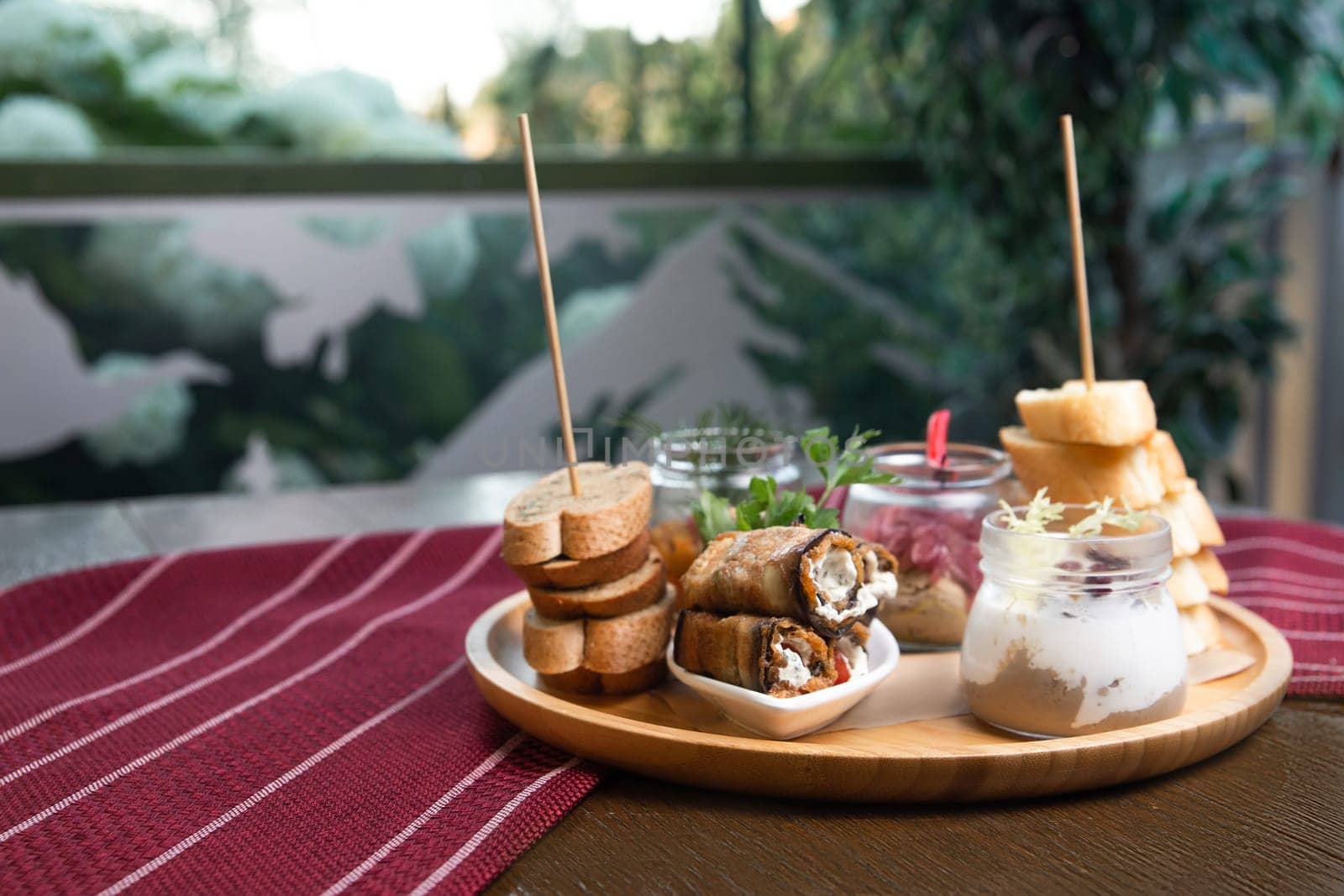 assorted snacks in jars on a wooden stand on the table by Pukhovskiy