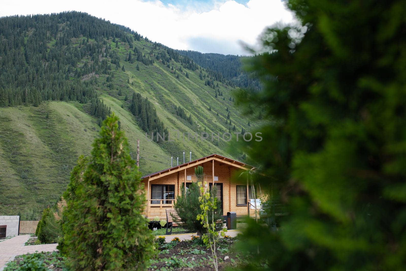 a wooden house outside the city in a mountainous area among trees.