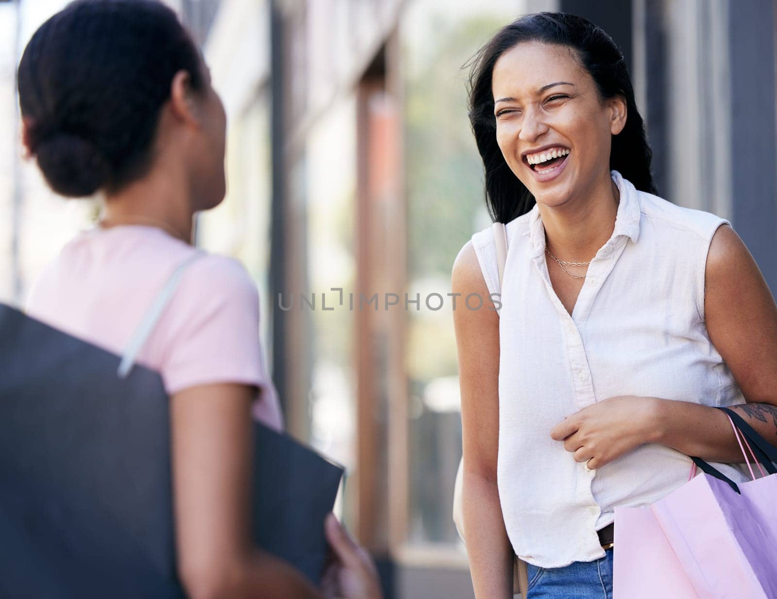 Woman, friends and laughing with shopping bags for conversation, catch up or social communication in the outdoors. Happy women enjoying funny shopping spree, talking or speaking together about sales.