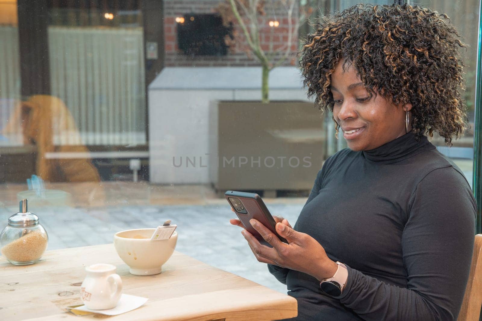 African american woman pays for the order in cafe using the application on the smartphone, technology use concept, wi-fi connection. High quality photo