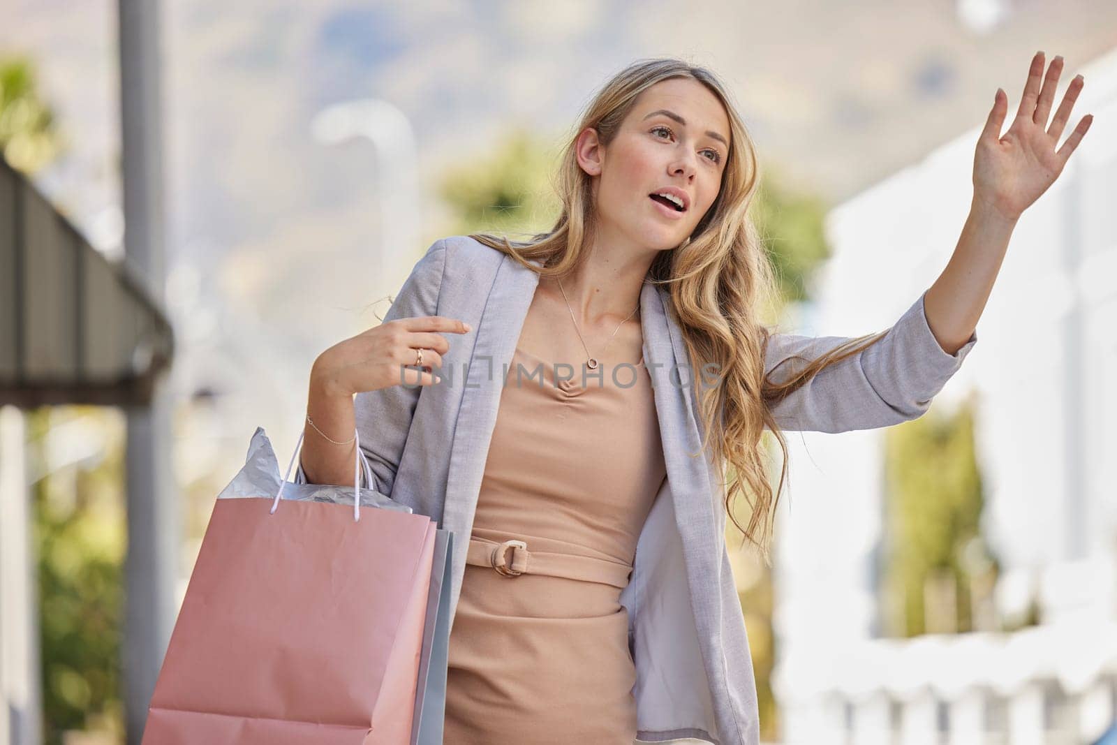 Shopping, city street and hand of woman for taxi in urban travel, wealth and luxury paper bag. Young person or customer with boutique, shopping bag in road call or waiting for transportation service.