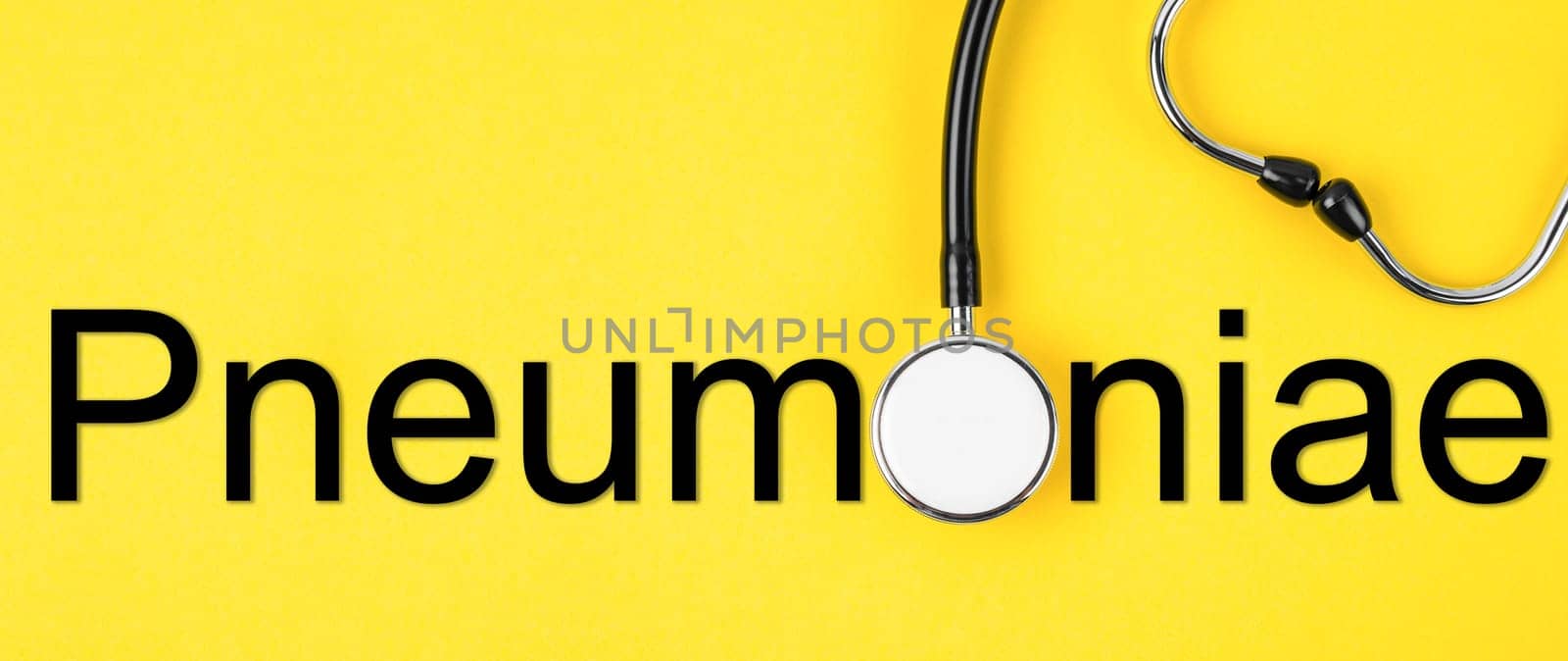 Pneumonia text and medical stethoscope on yellow background. Medcial and healthcare concepts.