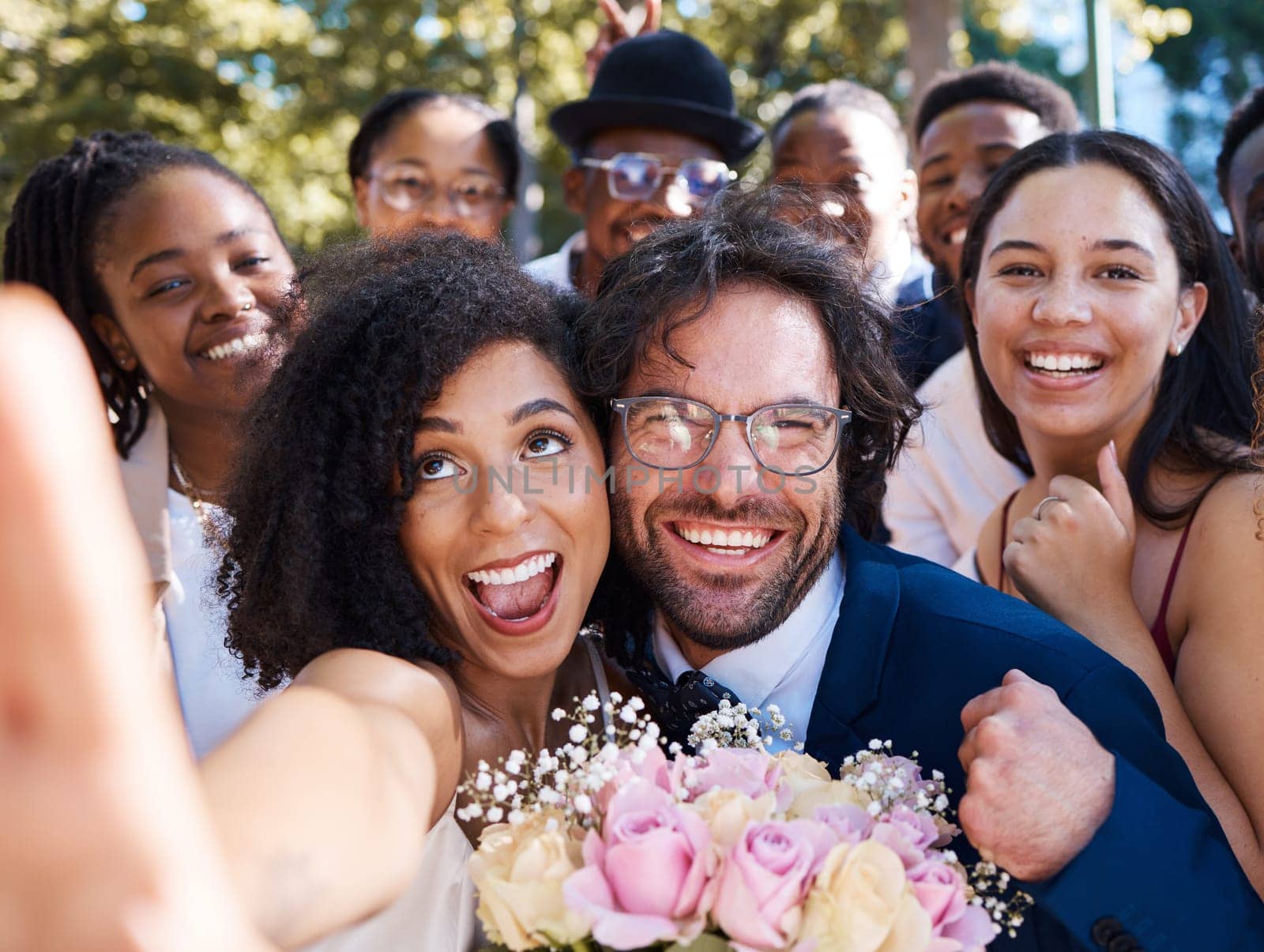 Friends, bride and groom with wedding selfie for outdoor ceremony celebration of happiness, love and joy. Marriage, happy and interracial relationship photograph of togetherness with excited guests.