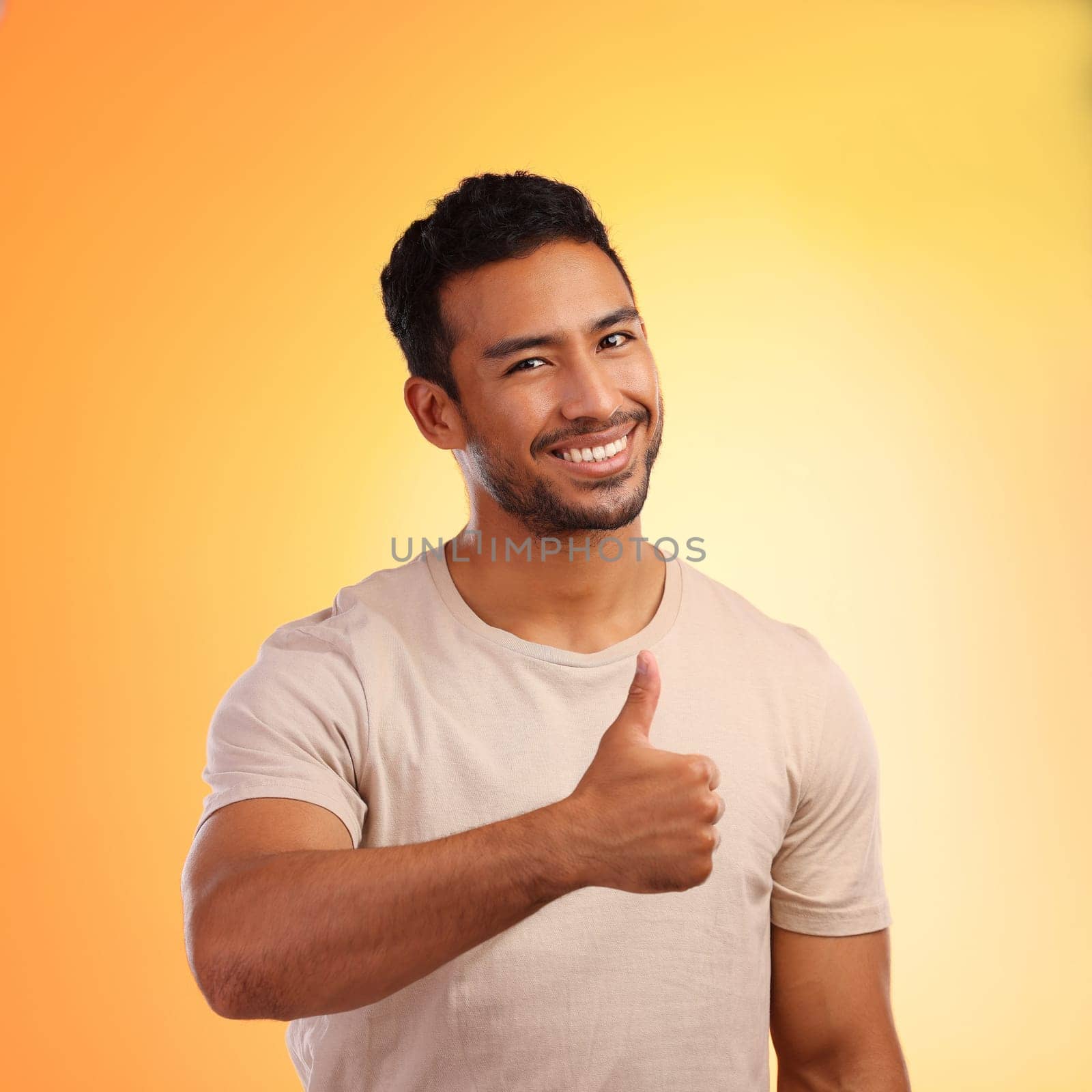 Hands, thumbs up and portrait of man in studio isolated on a yellow background. Face, fashion and happy male model with hand gesture for like emoji, motivation or success, agreement or thank you. by YuriArcurs
