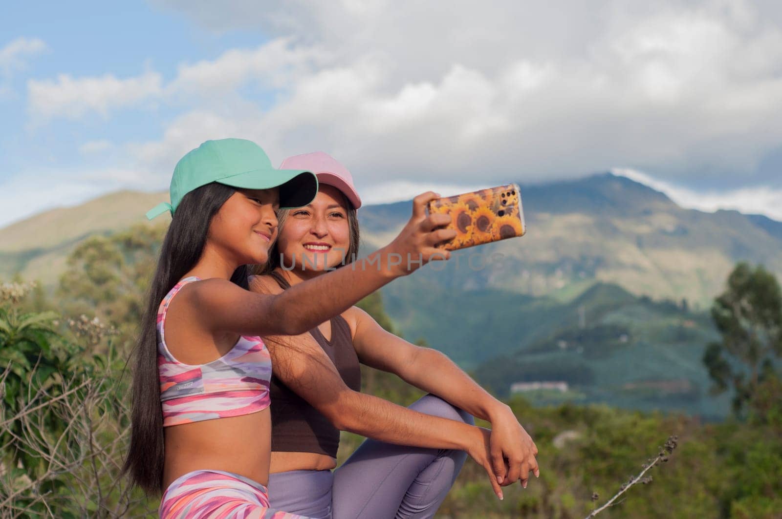 mom and daughter taking a selfie with a cell phone on a sunny day on vacation. High quality photo