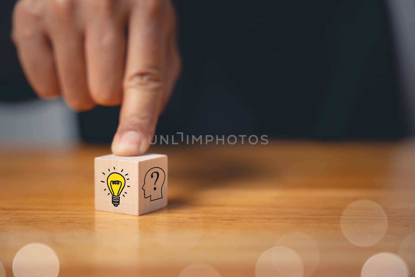 Expert consulting and creative solution concept. Hand holding wooden block with glowing light bulb icon. Development of new ideas and innovation strategy. Business success through creative imagination