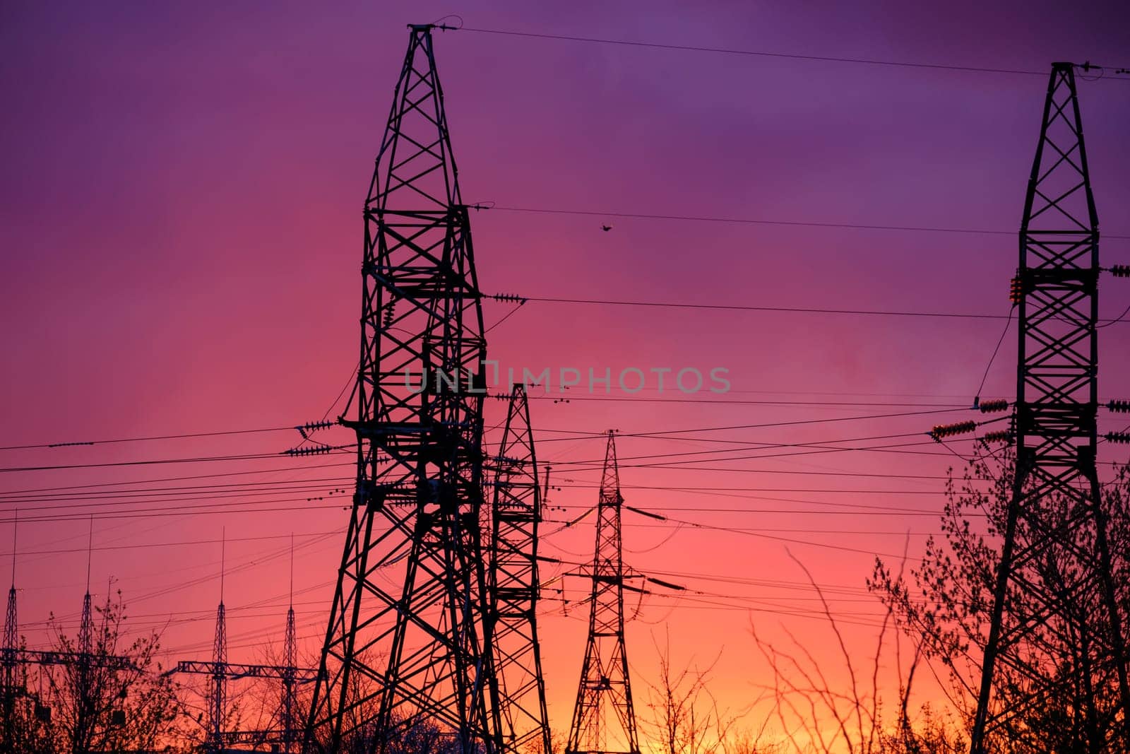 View of high voltage pole power transmission tower on sunset. Panorama high voltage tower with power lines. Download high quality photo