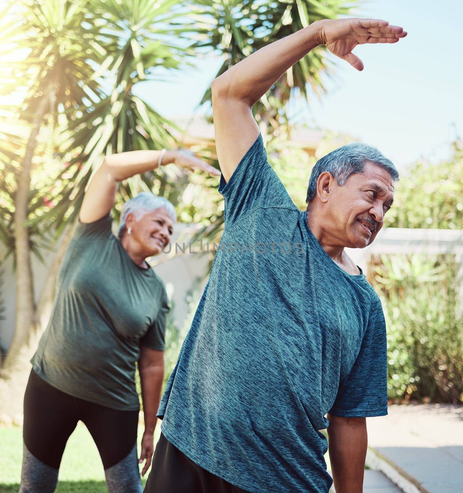 Fitness, yoga and health with a senior couple outdoor in their garden for a workout during retirement. Exercise, pilates and lifestyle with a mature man and woman training together in their backyard by YuriArcurs