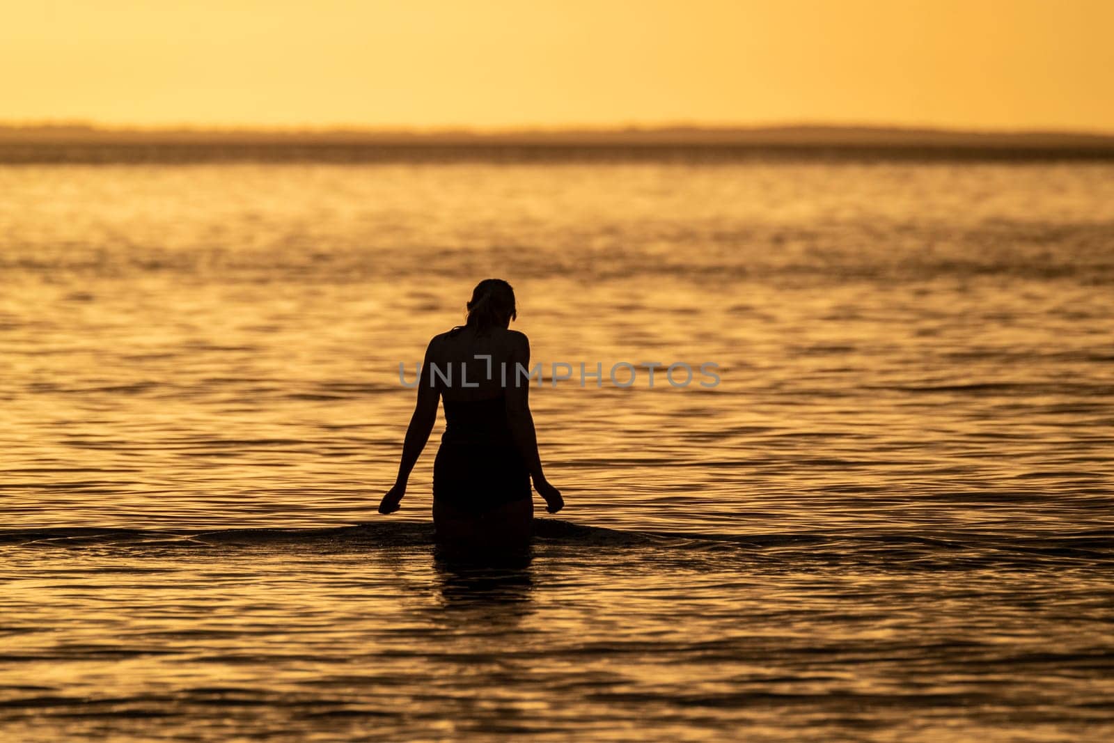 Silhouette of female swimmer going into the Atlantic ocean in Ireland by TLC_Automation