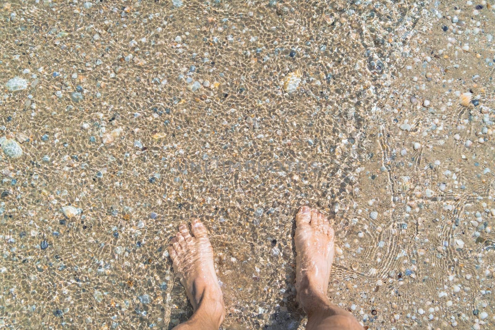 man walking barefoot in the sand in summer holidays on beach. High quality photo