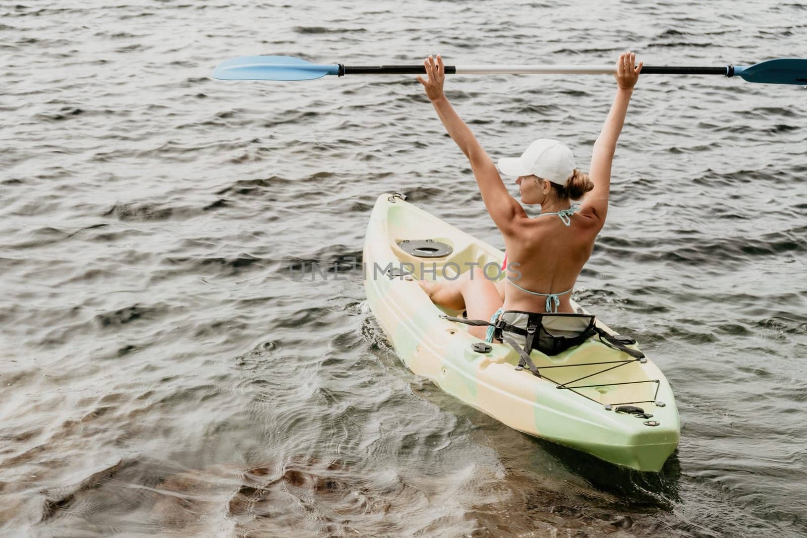 Woman kayak sea. Happy woman kayaks in sea, capturing outdoor memory with happy tourist taking photo. Volcanic mountains surround traveler on adventurous journey in kayak canoe. by panophotograph