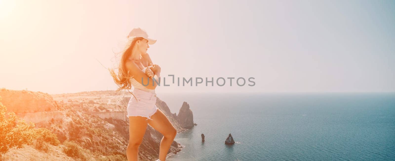 Woman summer travel sea. Happy tourist enjoy taking picture outdoors for memories. Woman traveler posing over sea bay surrounded by volcanic mountains, sharing travel adventure journey by panophotograph