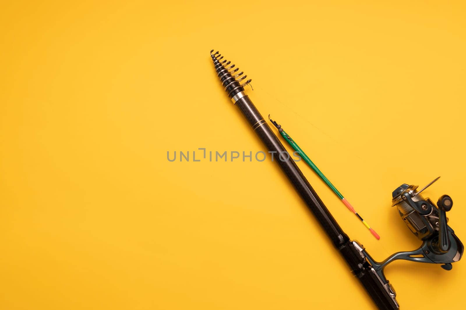 Design Fishing Spinning Rod, Reel on Yellow Background. Hobby, Leisure. Mockup, Copy Space for Text. Horizontal Plane. High quality photo