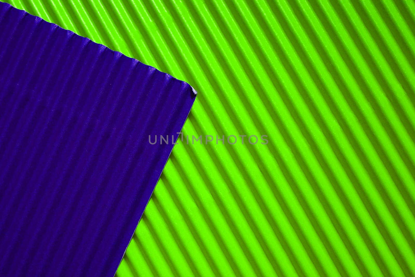 Diagonally ribbed cardboard with the colors neon green and deep purple. Meant as background