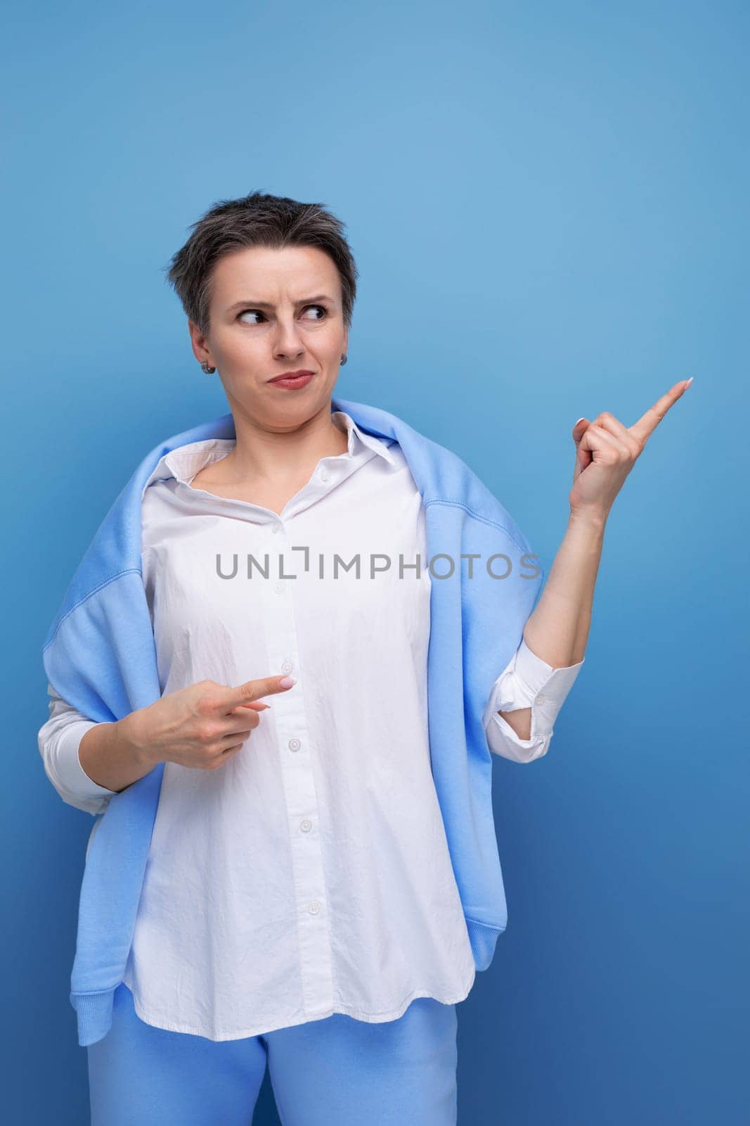 portrait of charismatic young millennial woman with short haircut pointing finger by TRMK