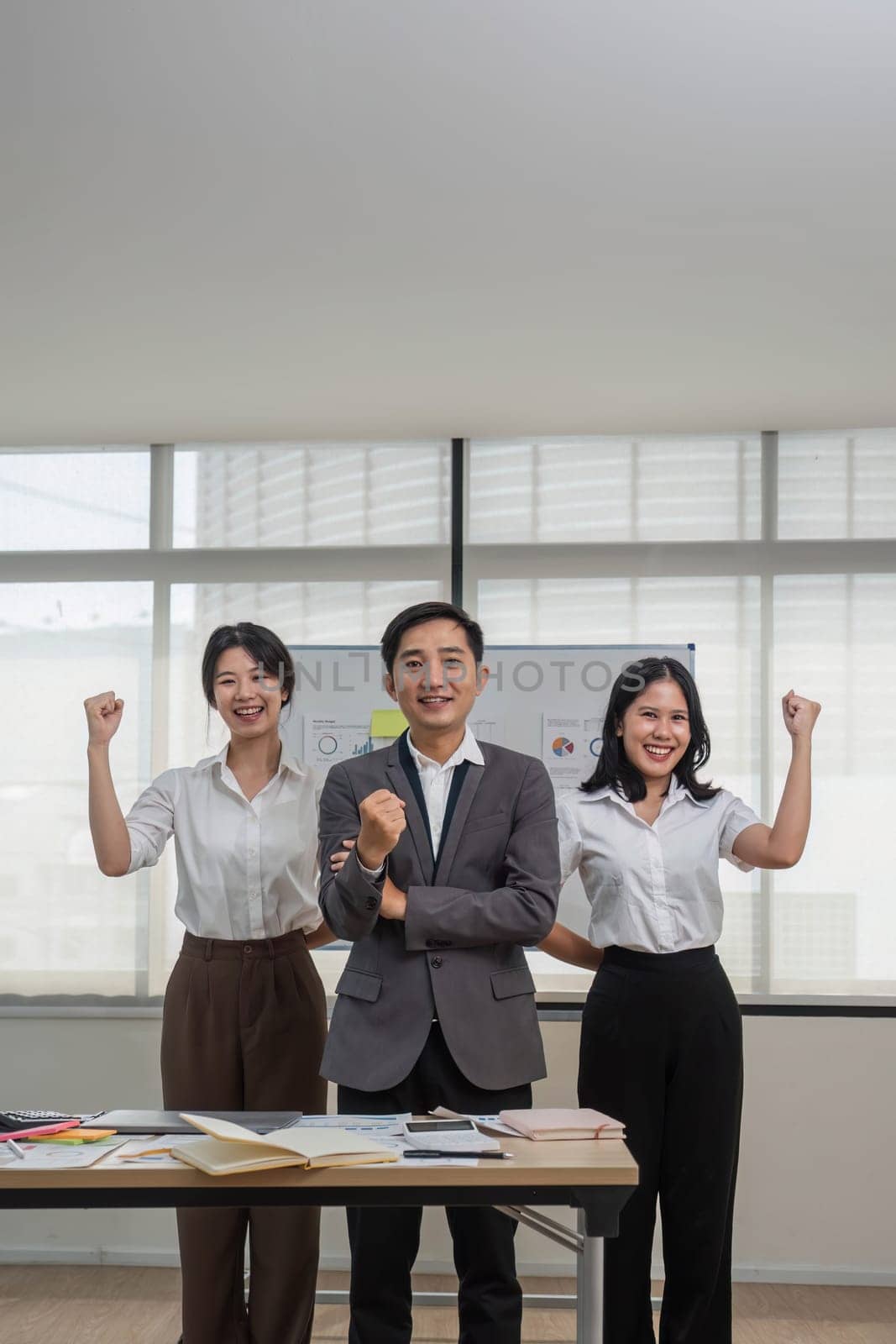 Portrait of smiling group Asian professional confident business people team standing and looking at camera by wichayada