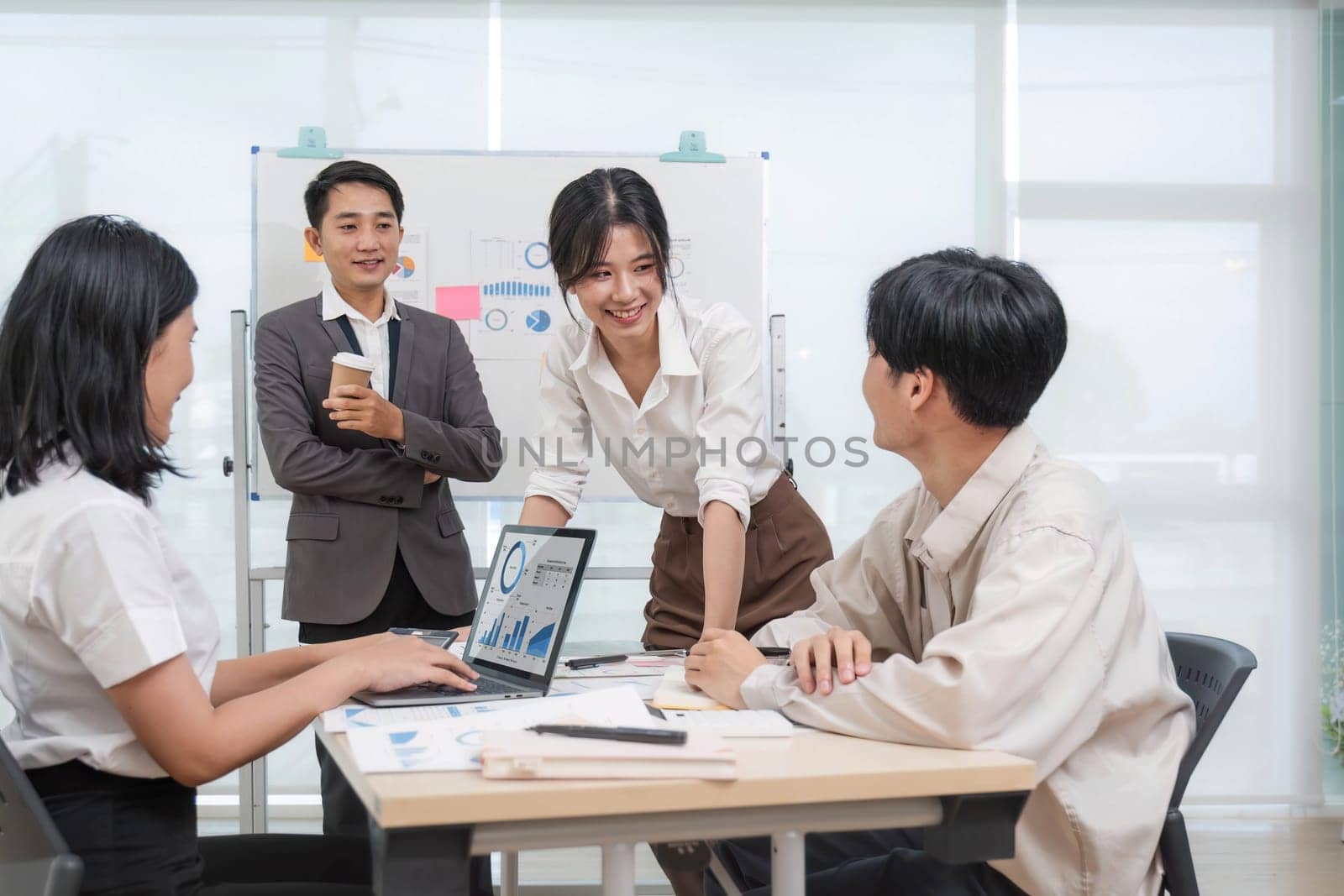 Group of creative asian business meeting and discussing strategy startup project analysis finance .Success asian business people work plan and brainstorm marketing idea with laptop in office.Teamwork by wichayada