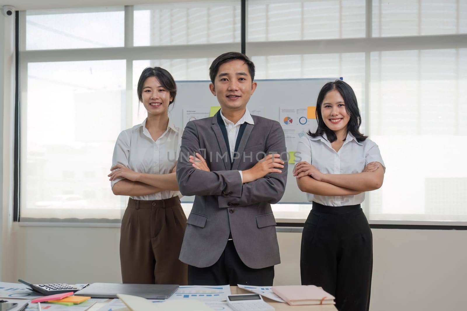 Portrait of smiling group Asian professional confident business people team standing and looking at camera by wichayada