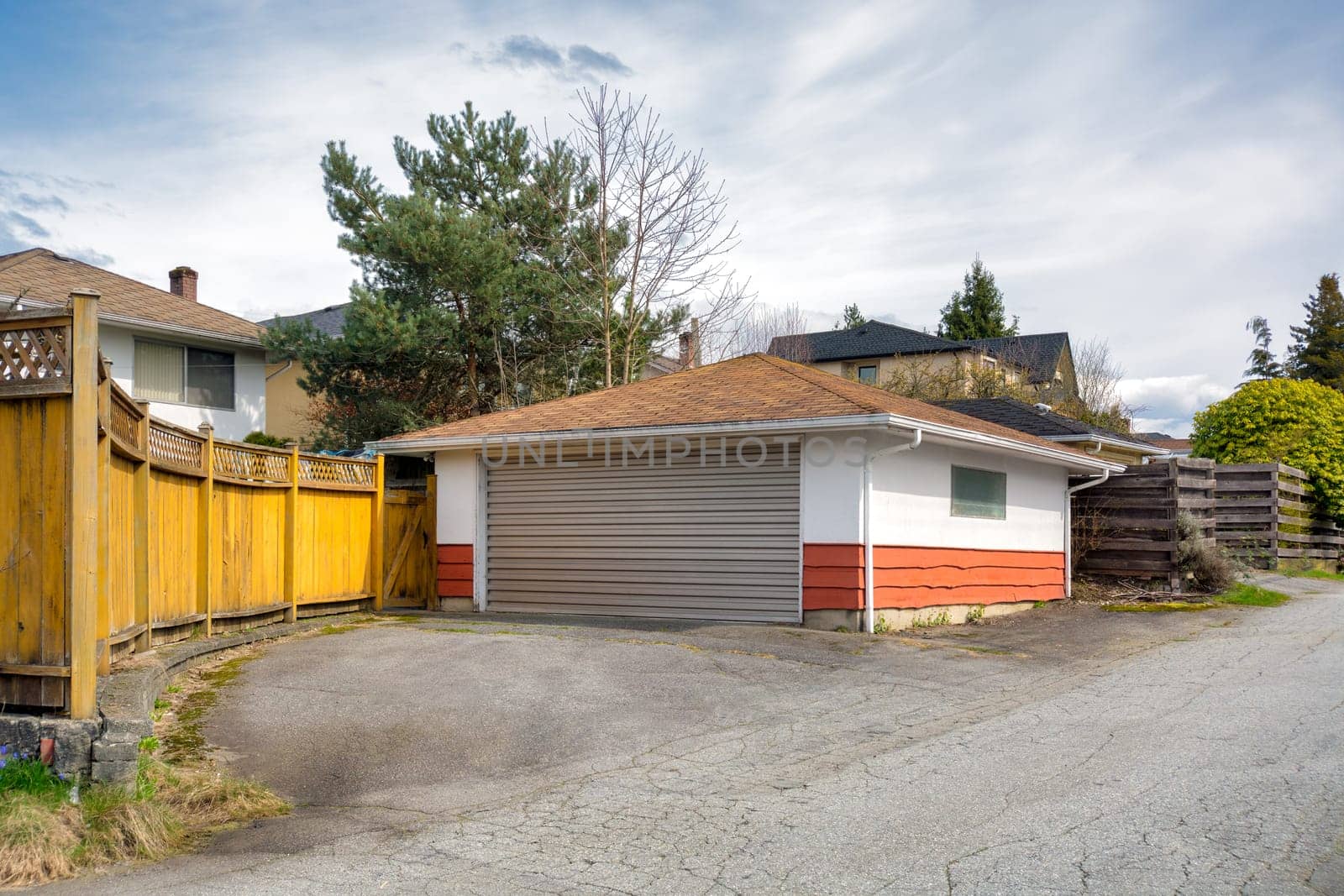 Detached garage of residential house with asphalt road in front.