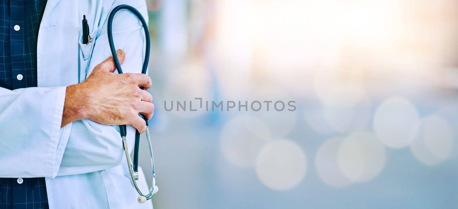 Hand, stethoscope and healthcare on mockup with a doctor man standing in a hospital for insurance. Medical, trust and mock up with a male medicine professional in a clinic for health or treatment by YuriArcurs