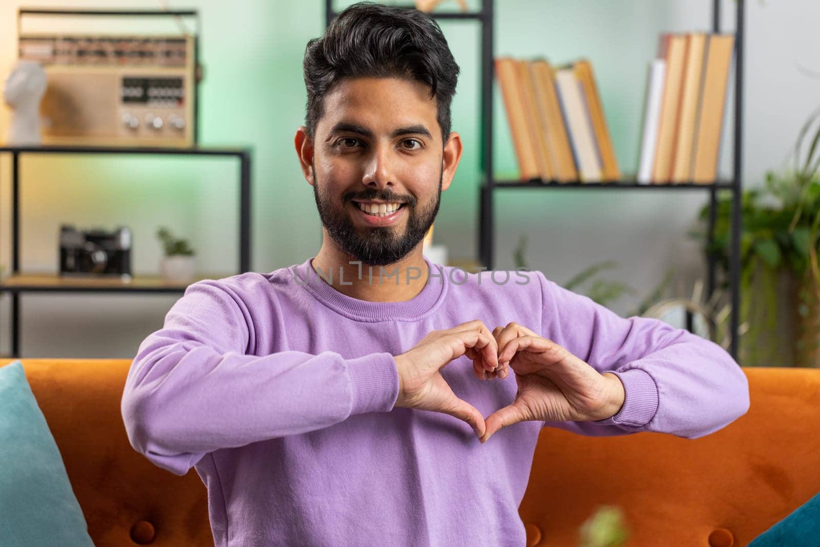 Happy indian man guy makes symbol of love showing heart sign to camera express romantic feelings by efuror