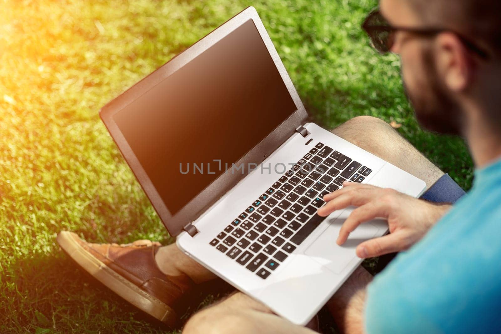 Top view male hands using notebook outdoors in urban setting while typing on keyboard, businessman freelancer working on computer while sitting on city park bench, tourist working on laptop, filter. Sun flare