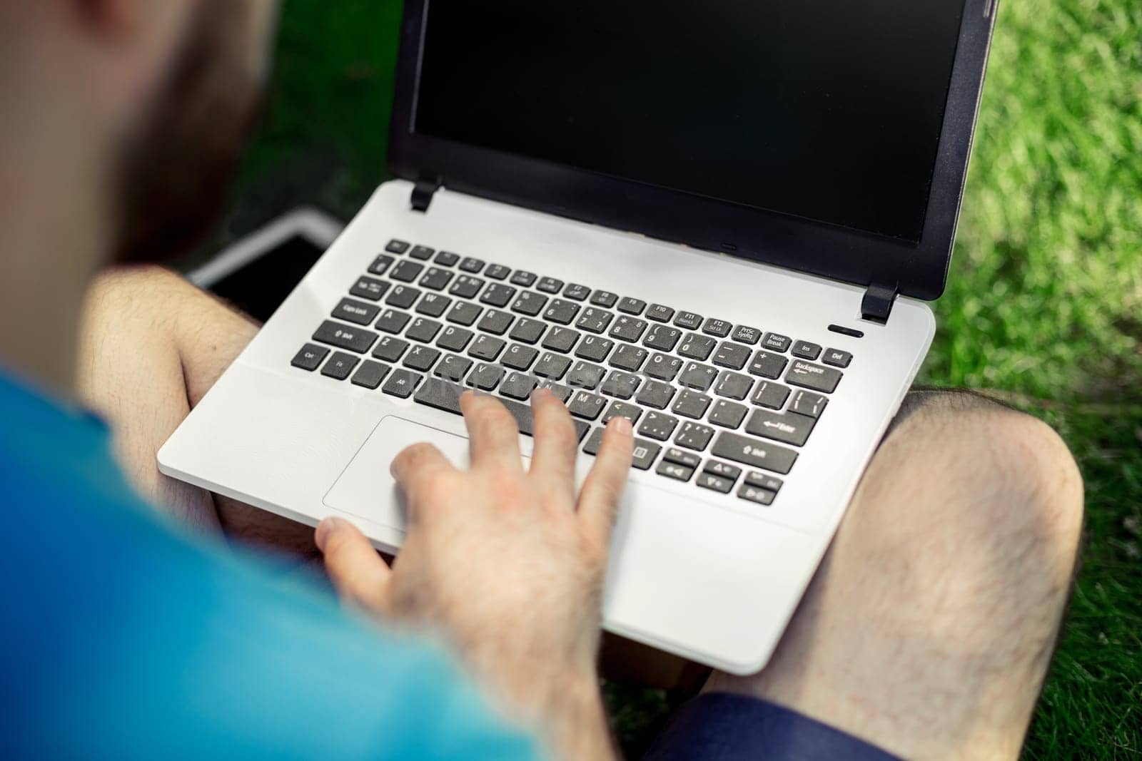 Top view male hands using notebook outdoors in urban setting while typing on keyboard, businessman freelancer working on computer while sitting on city park bench, tourist working on laptop, filter