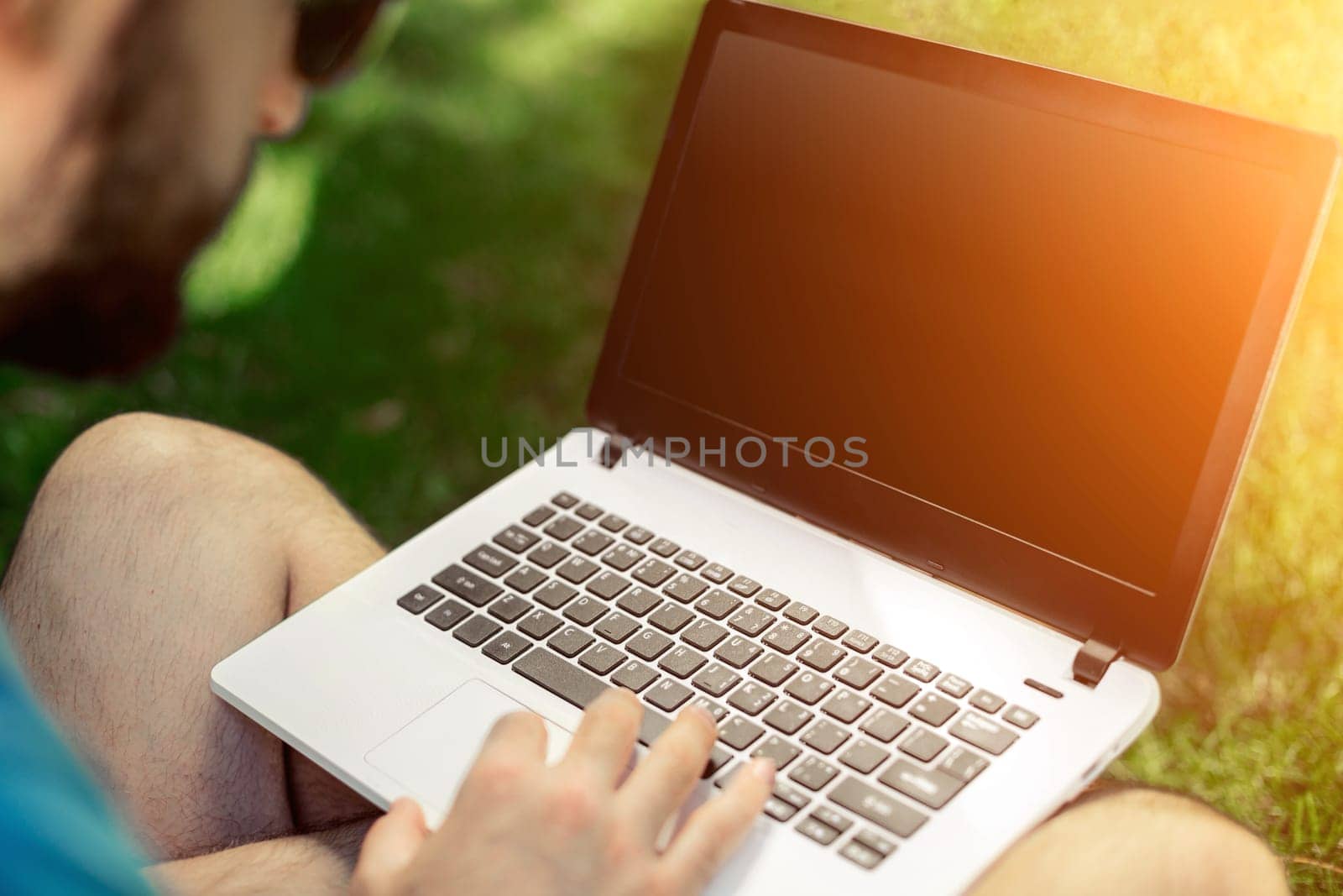 Top view male hands using notebook outdoors in urban setting while typing on keyboard, businessman freelancer working on computer while sitting on city park bench, tourist working on laptop, filter. Sun flare