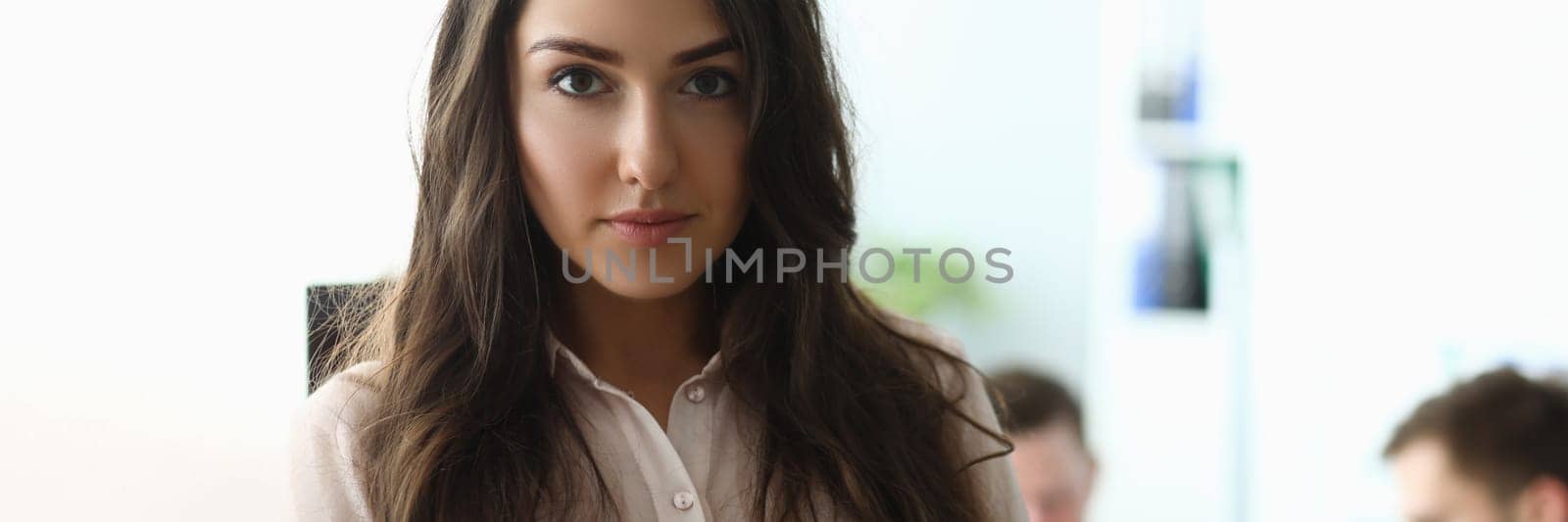 Portrait of young businesswoman in the background is employee working. Successful boss boss and career in business concept