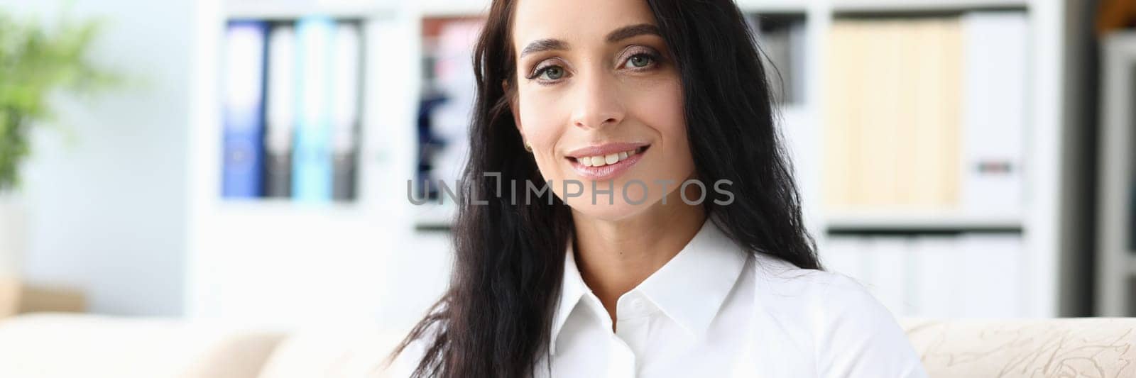 Beautiful smiling woman is reading book in living room. Education and reading books concept