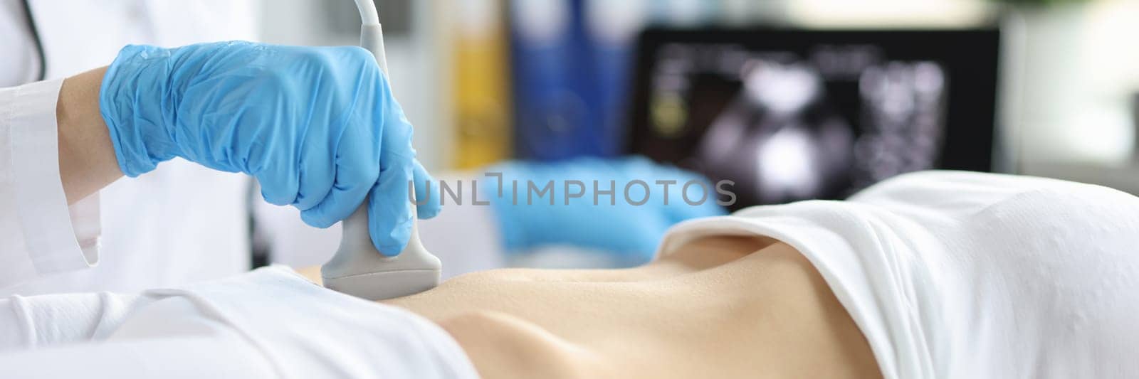 Sonographer technician holds ultrasound probe to diagnose condition of pregnant woman looking at woman uterus on computer screen. Ultrasound of uterus and female reproductive system concept