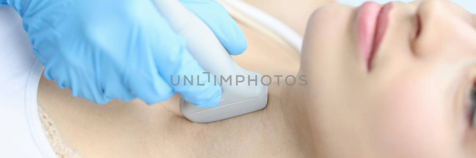 Scanning the thyroid gland of woman in medical clinic closeup. Research reflecting location of endocrine gland in women concept