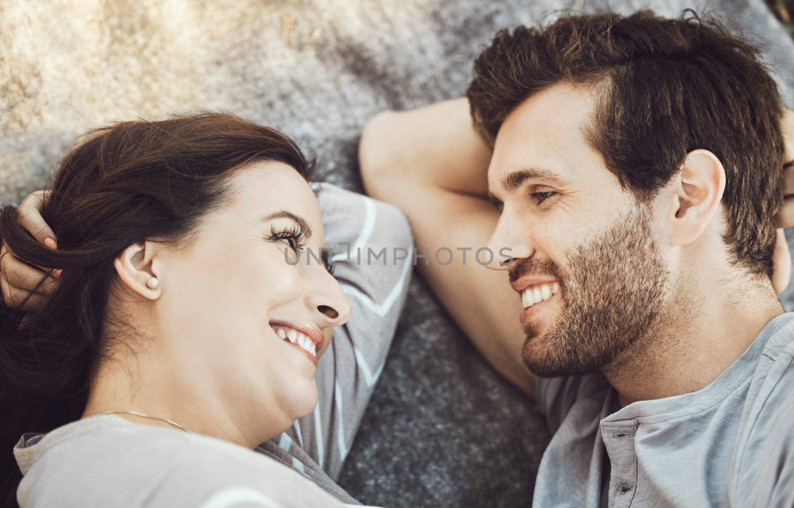 Love, couple romance and relax, talking and having fun time together outdoors on valentines day. Trust, support and face of happy man and woman lying on romantic date, smile and having conversation
