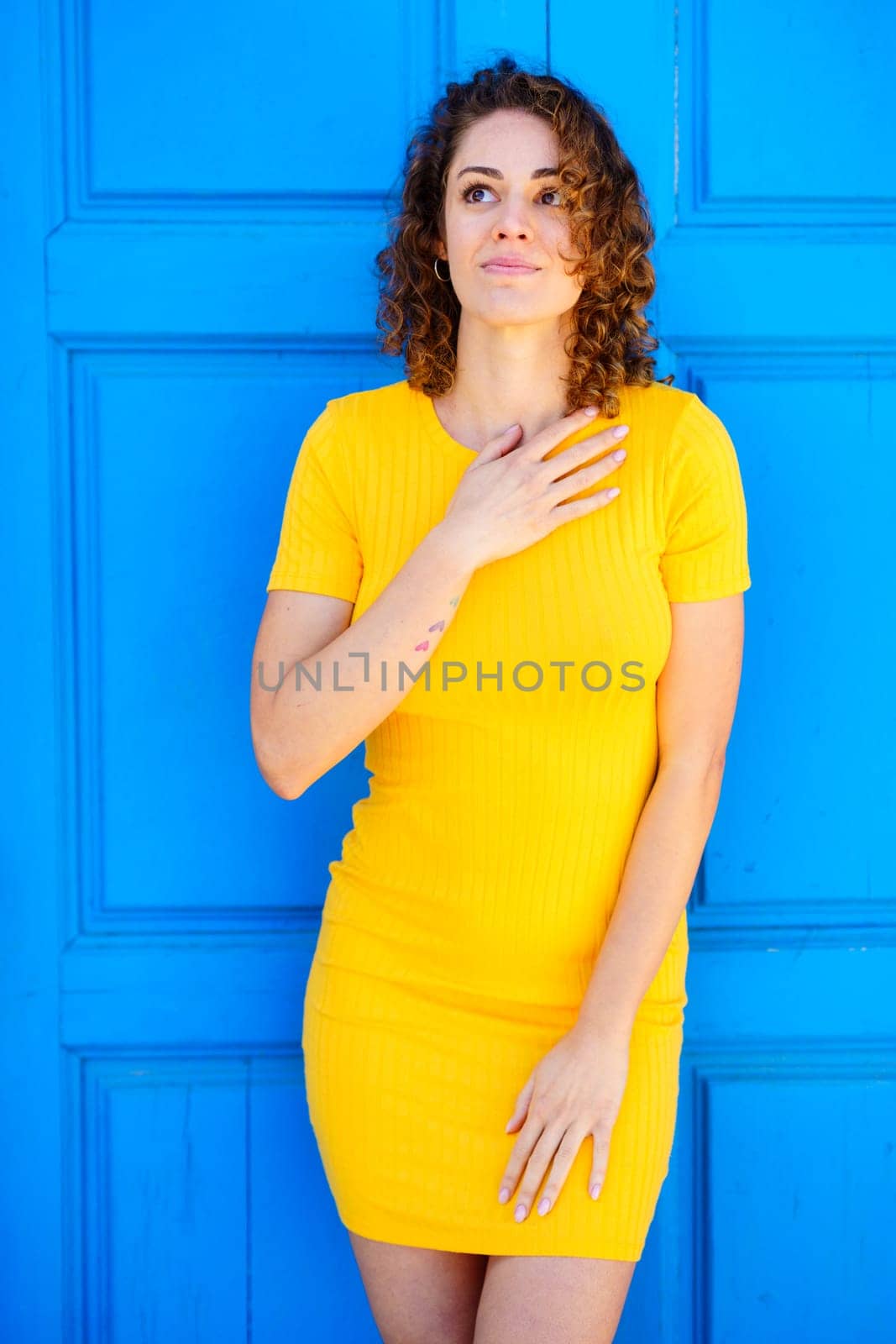 Charming woman touching chest and looking up by javiindy