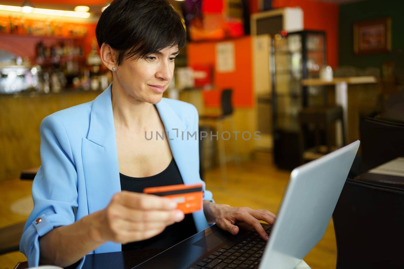 Adult woman using debit card for online payment by javiindy