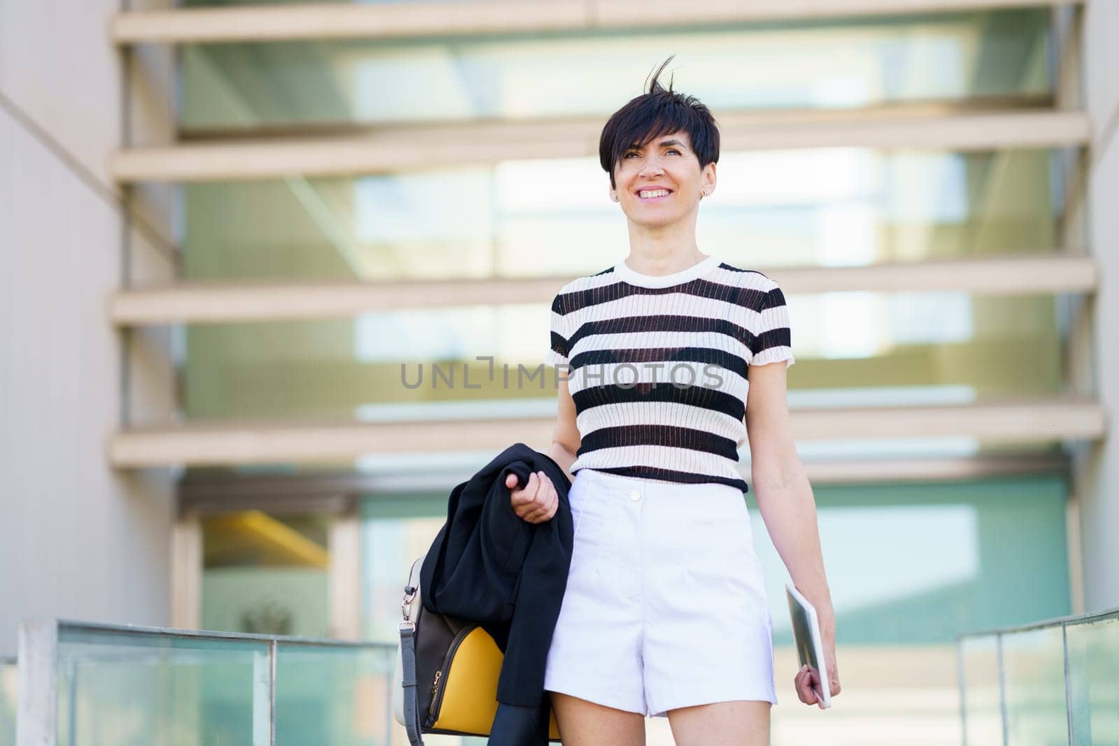 Happy adult woman with bag and tablet by javiindy